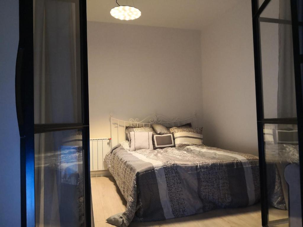 a bedroom with a bed in a room with a mirror at Mario Studio in Vilnius