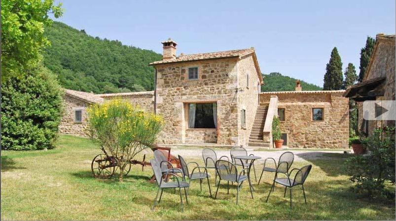 a group of chairs and tables in front of a building at Villa Case Belle in Sarteano