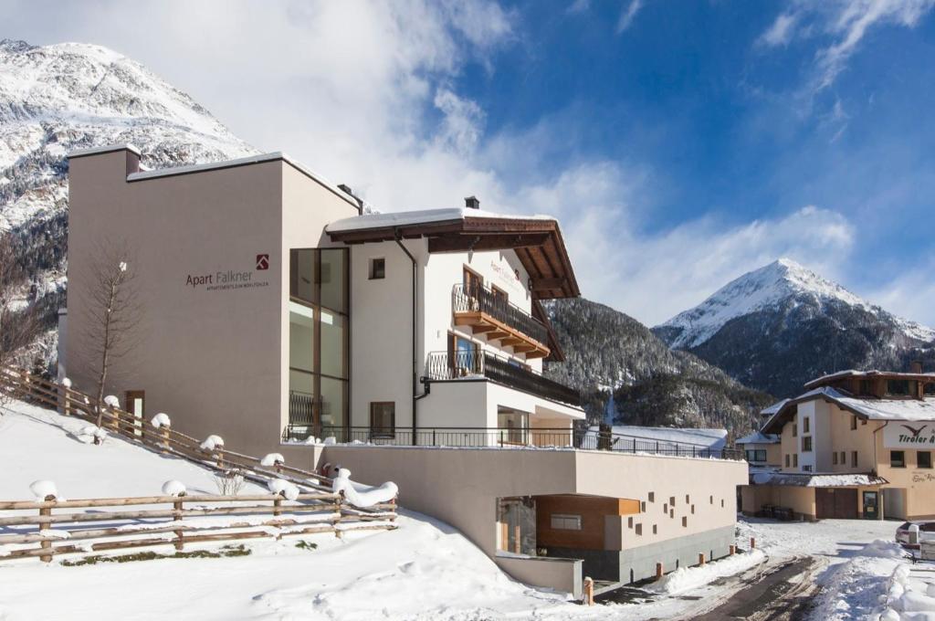 un edificio en la nieve con montañas en el fondo en Apart Falkner, en Sölden