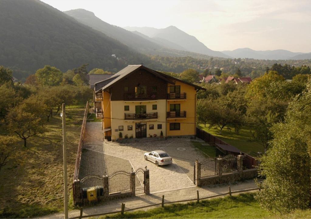 une maison avec une voiture garée sur un parking dans l'établissement Casa Dracula by Pro Lex, à Bran