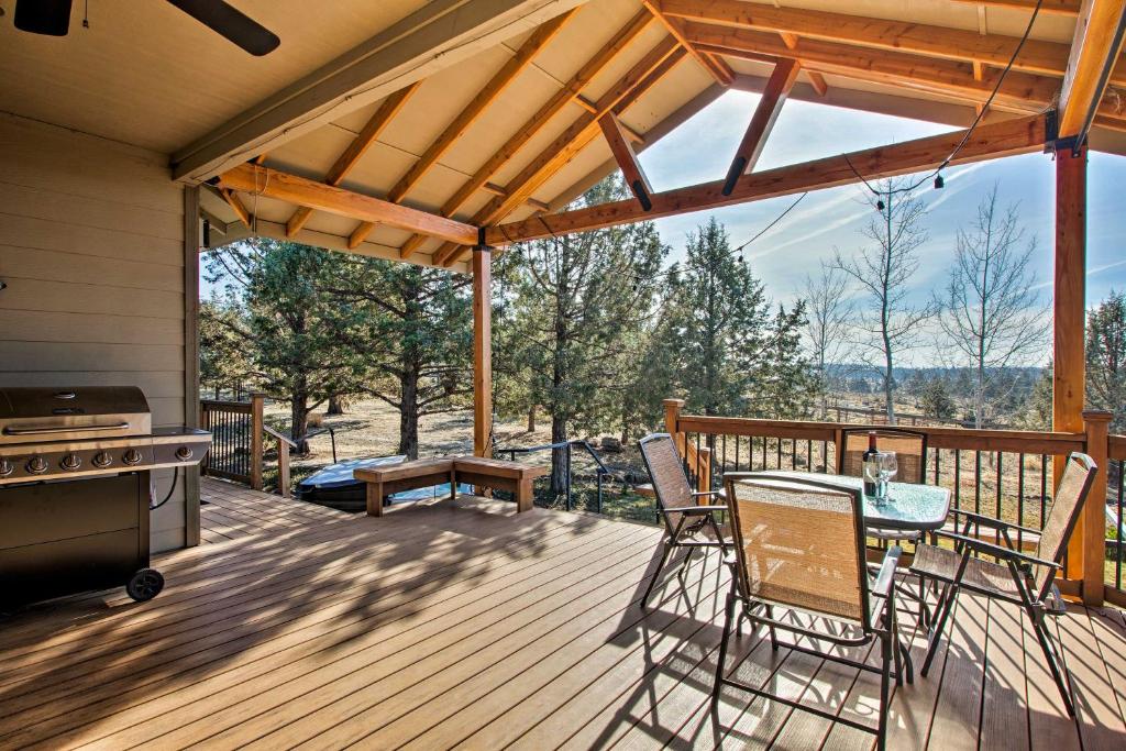 a deck with a table and chairs and a grill at Grand Cabin with Hot Tub and Views - 3 Miles to Hiking in Terrebonne