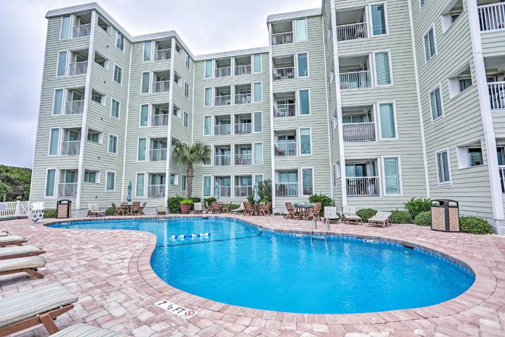 an image of a swimming pool in front of a building at Sands Beach Club Condo with Ocean Views and Amenities! in Myrtle Beach