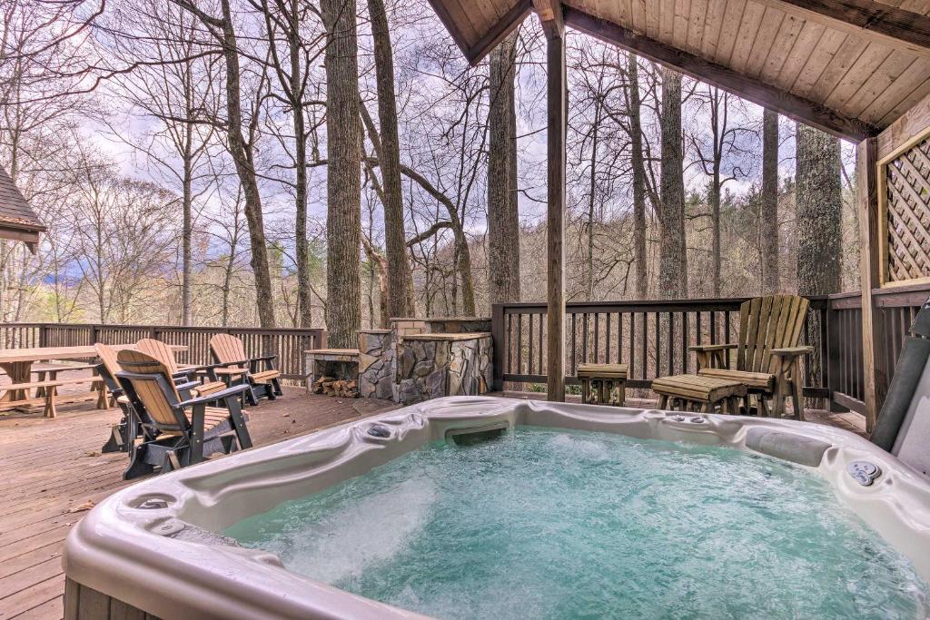 einen Whirlpool auf einer Terrasse mit einem Tisch und Stühlen in der Unterkunft The Fox Wood in Blue Ridge Mtns By Grandfather Mtn in Boone