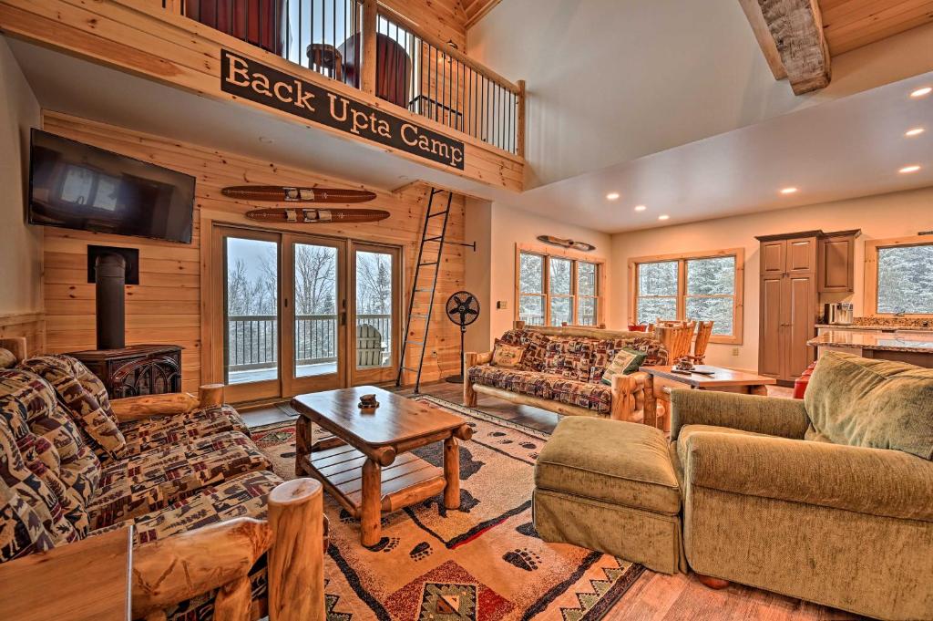 a living room filled with furniture in a log cabin at Rustic 3-Story Pittsburg Cabin with Lake and Mtn Views in Pittsburg