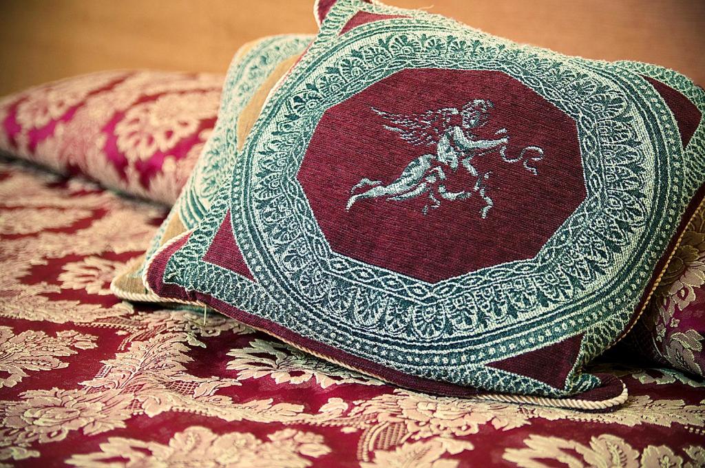 a pillow with an angel on it sitting on a bed at Parioli House in Rome