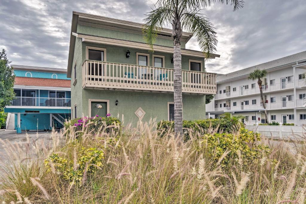 a palm tree in front of a building with a balcony at Central Venice Apartment with Balcony, Walk to Beach in Venice