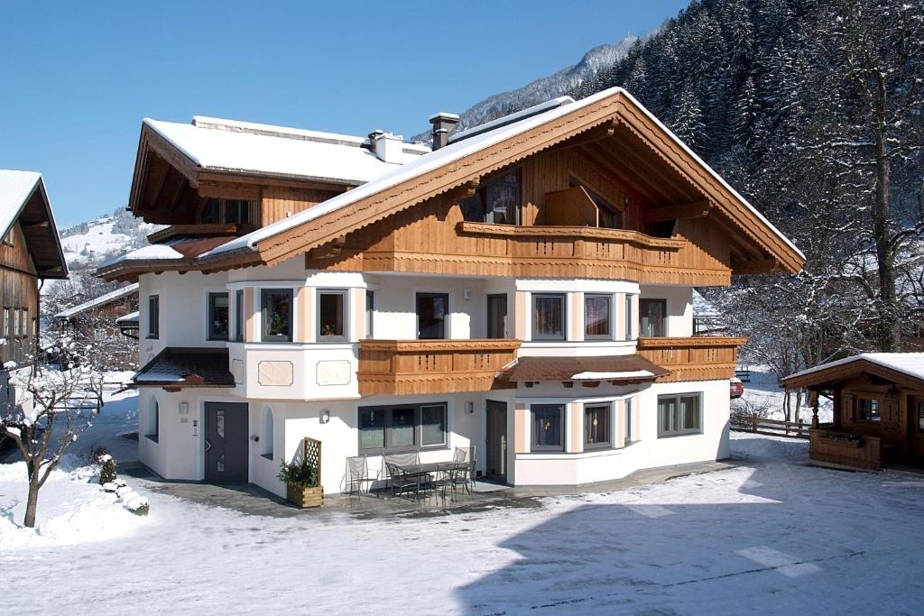 una casa en la nieve frente a una montaña en Appartement Zottl, en Mayrhofen