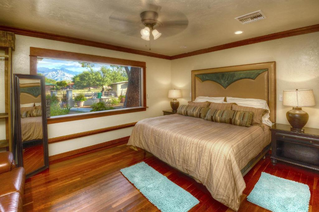 a bedroom with a bed and a large window at Tucson Casita with Courtyard, Hot Tub and Fire Pits! in Tucson