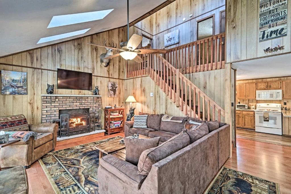 a living room with a couch and a fireplace at Bear Den Rustic Pocono Lake Home with Game Room! in Pocono Lake