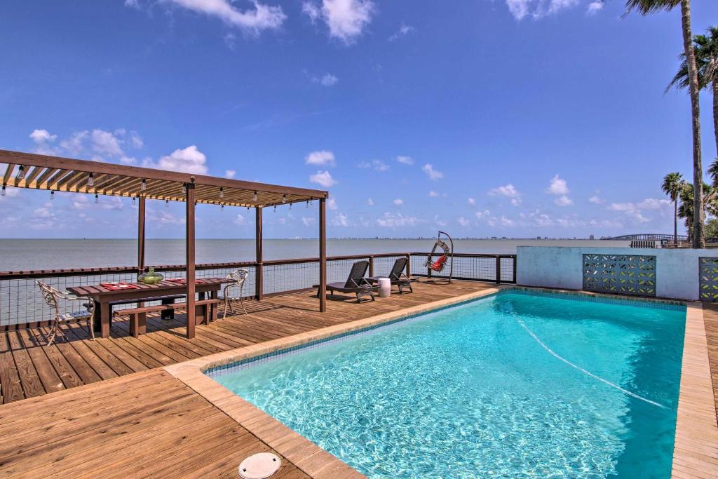 una piscina en una terraza junto a la playa en Waterfront Port Isabel Family Home with Pool and Pier!, en Port Isabel
