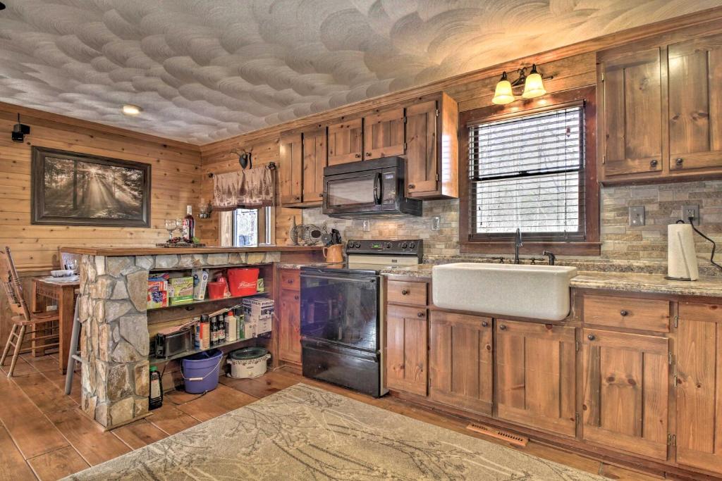 a kitchen with wooden cabinets and a sink at Carters Hideaway by Fairy Stone Pool and Hot Tub in Henry