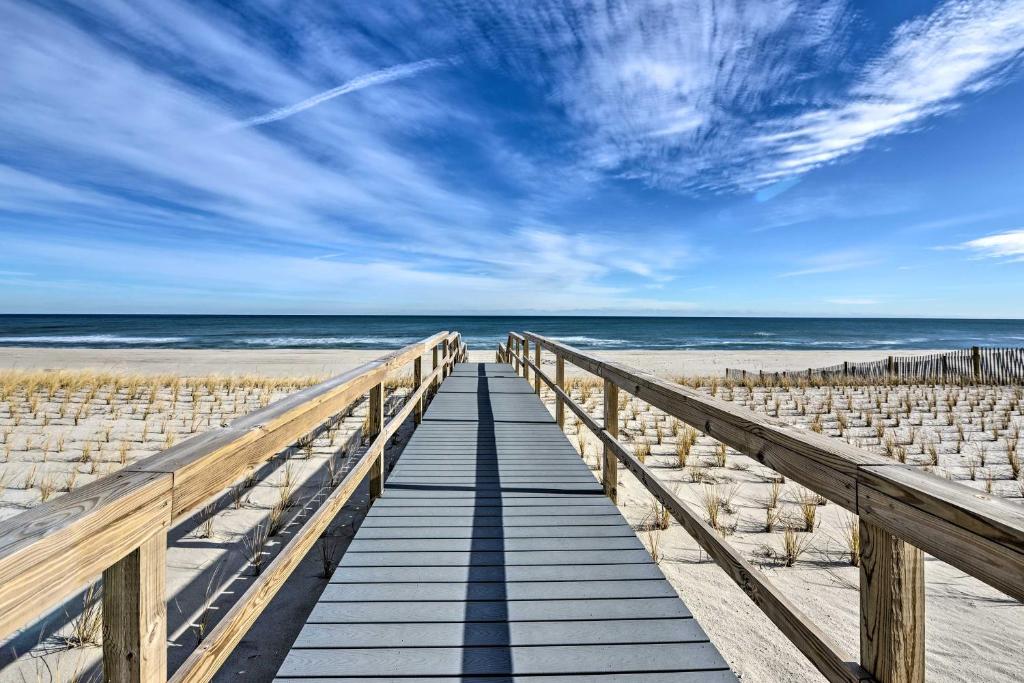 a wooden boardwalk to the beach with a blue sky at Oceanside Beach House in Pvt Beach Community! in Mantoloking