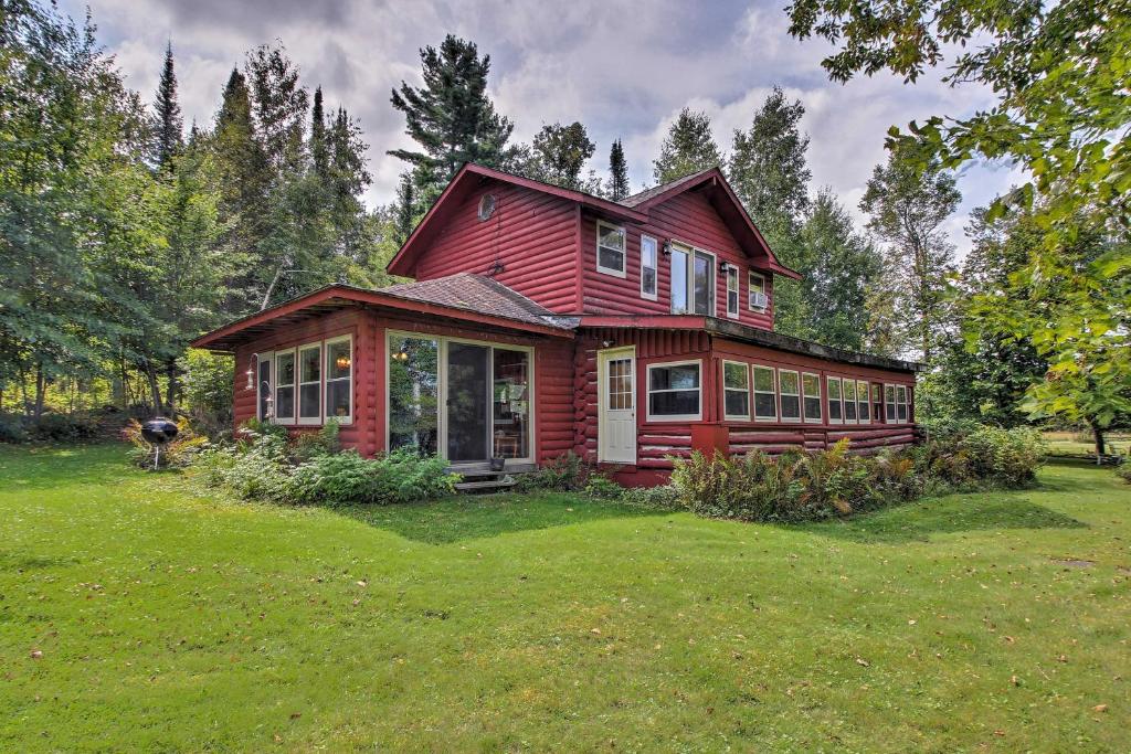 ein rotes Haus auf einem üppigen grünen Feld in der Unterkunft Wilderness Acres Retreat on Bear Lake! in McGrath