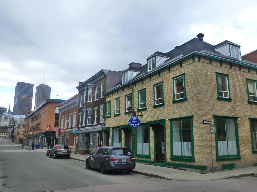 un edificio de ladrillo en una calle de la ciudad con coches aparcados en GLOBE-TROTTER & BACKPACKERS HOSTEL, en Quebec