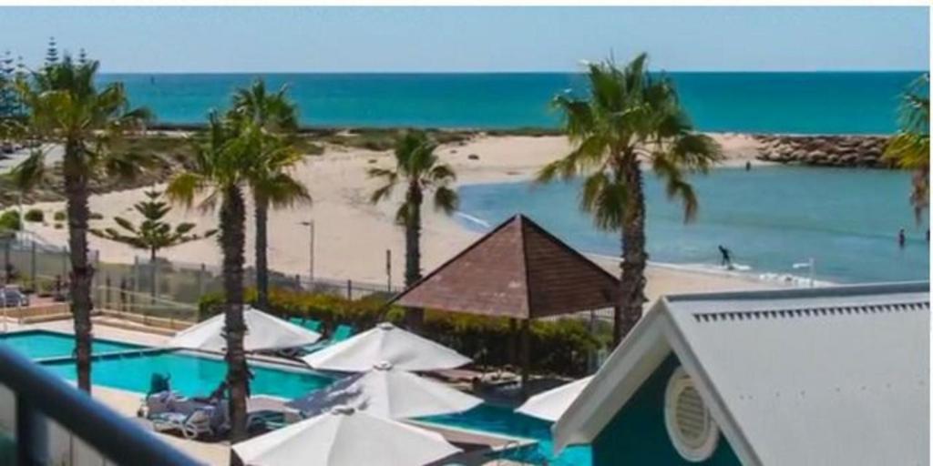 a view of the beach from the balcony of a resort at AN OCEAN,BEACHFRONT AND POOL VIEW Apartment 210 in Mandurah