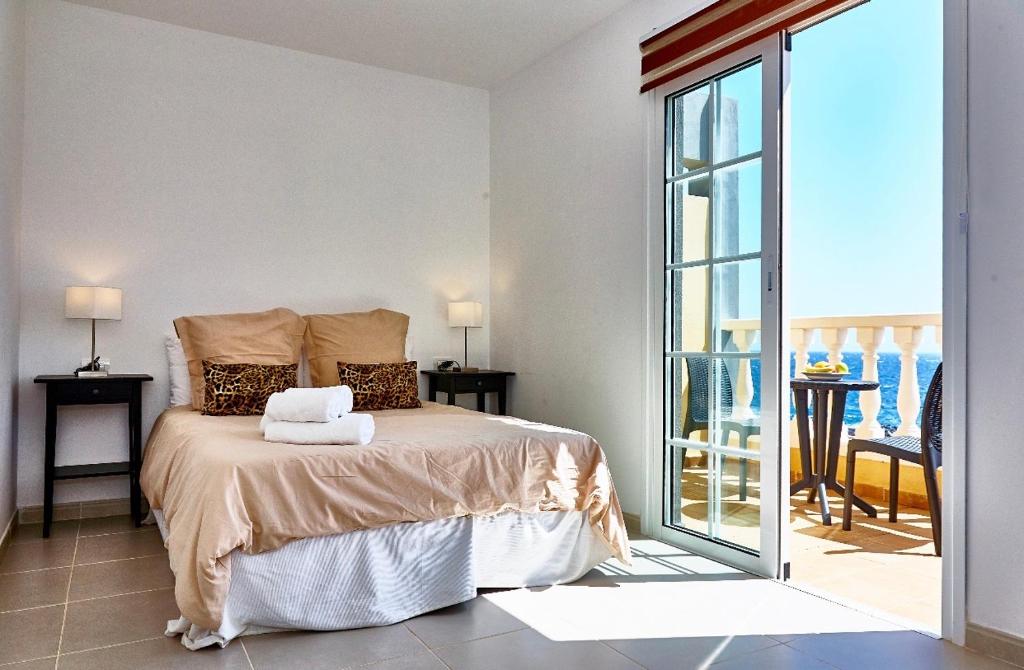 エル・メダノにあるMedano Beach Villasのベッドルーム(ベッド1台付)、バルコニーが備わります。