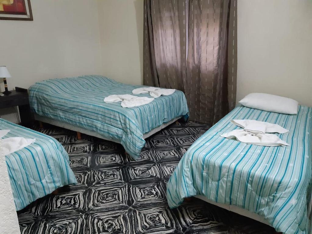 Dos camas en una habitación de hotel con toallas. en Hotel Santa Elena en San Clemente del Tuyú