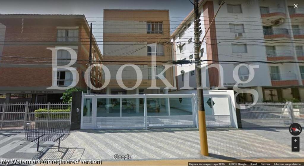 a building with a book sign in front of it at Apartamento Praia da Enseada in Guarujá