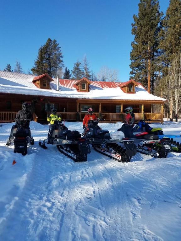 un grupo de personas de pie en la nieve frente a un lodge en The Wild Game Inn, en Alta