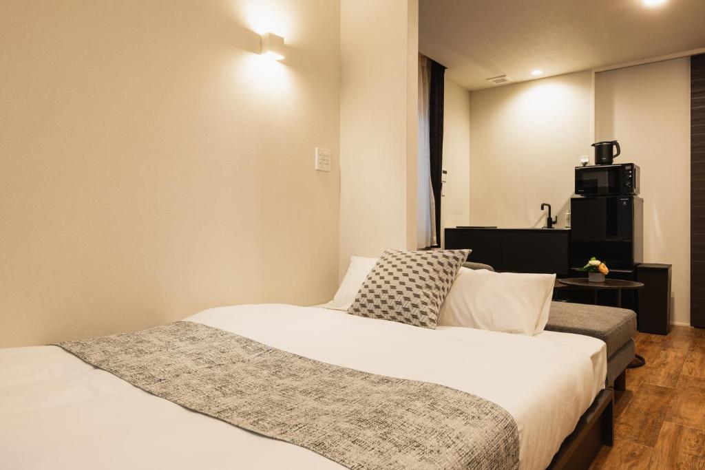 Postel nebo postele na pokoji v ubytování GRAND BASE Nagasaki