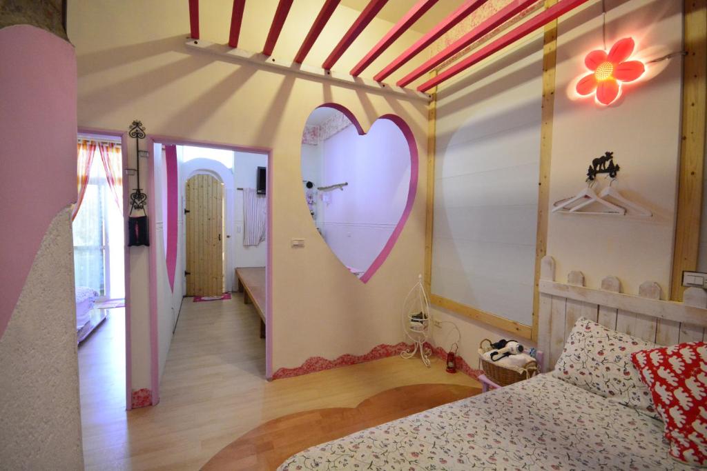 a bedroom with a large heart mural on the wall at Happiness Factory in Huxi