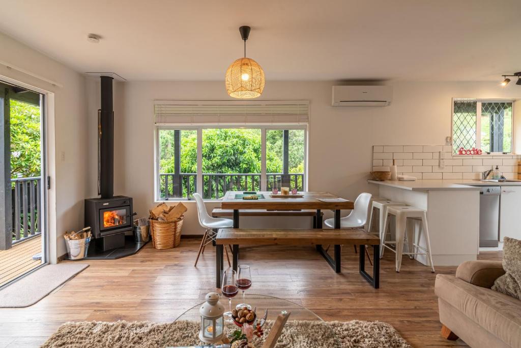 a living room with a table and a fireplace at La Petite Maison - Akaroa Holiday Home in Akaroa