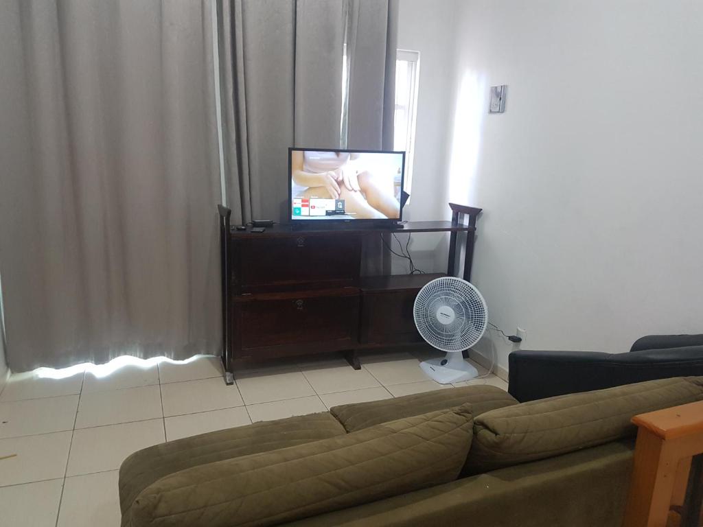 sala de estar con sofá y TV de pantalla plana en Apartamento exclusivo-hospedagem, en Joinville