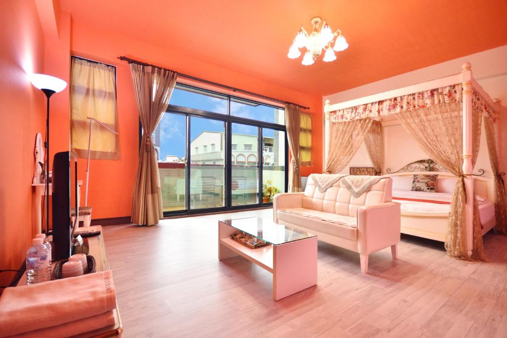 - un salon avec des murs orange, un lit et un canapé dans l'établissement Heng Bin Bed and Breakfast, à Taïtung