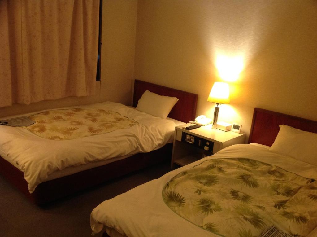 Postel nebo postele na pokoji v ubytování Jyonai Hotel