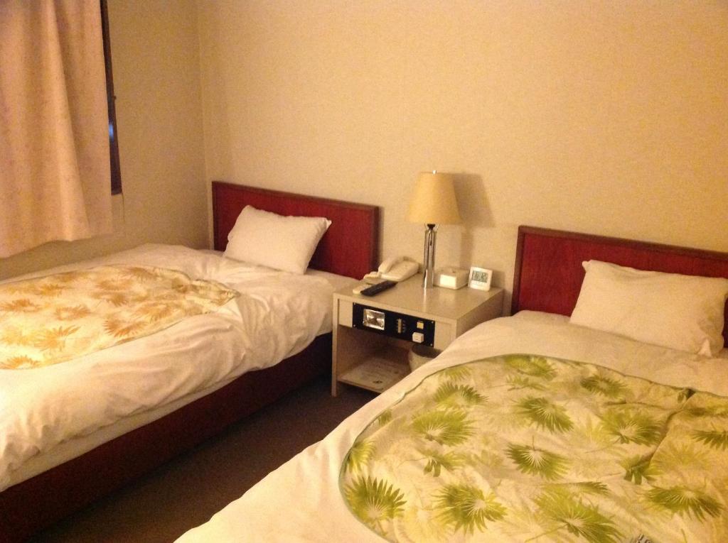 Postel nebo postele na pokoji v ubytování Jyonai Hotel