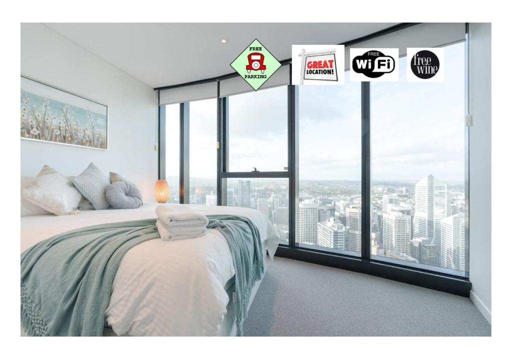 a bedroom with a bed and a large window at Lvl 57 Skytower Breathtaking Views CBD Wifi Carpark by Stylish Stays in Brisbane
