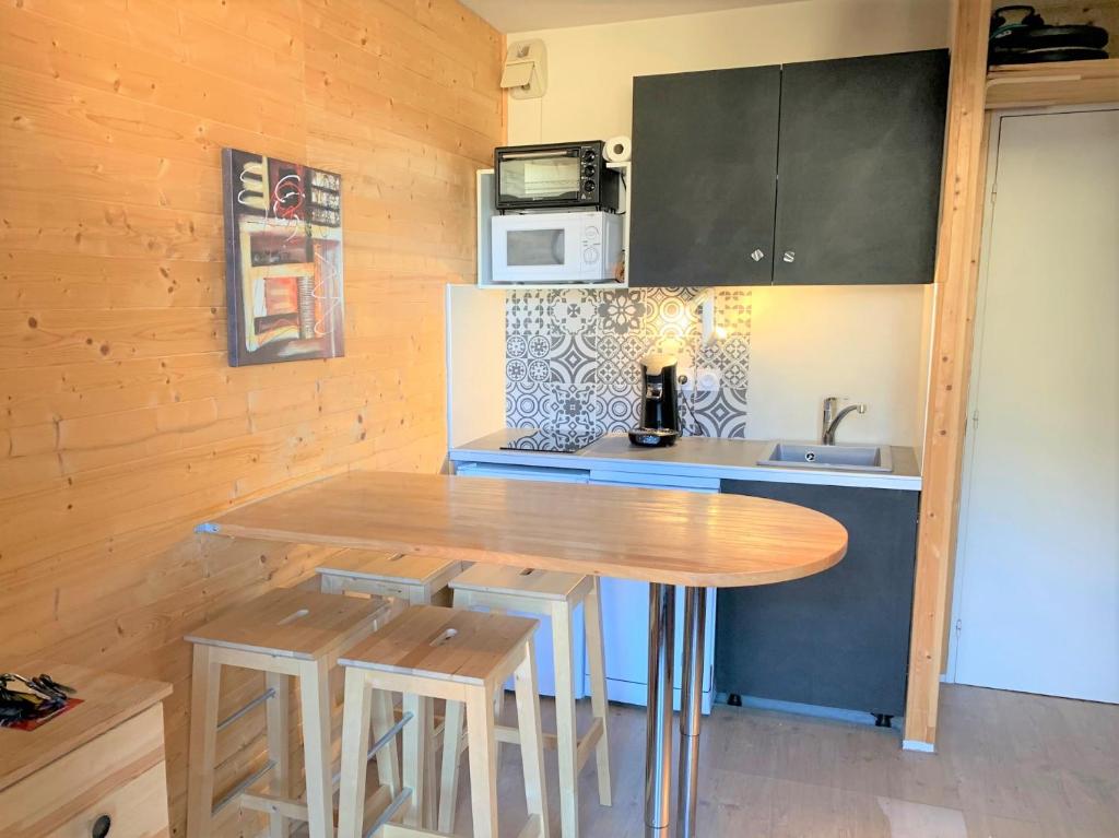- une cuisine avec une table en bois et un comptoir dans l'établissement L'esprit chalet by SODA, à Luchon