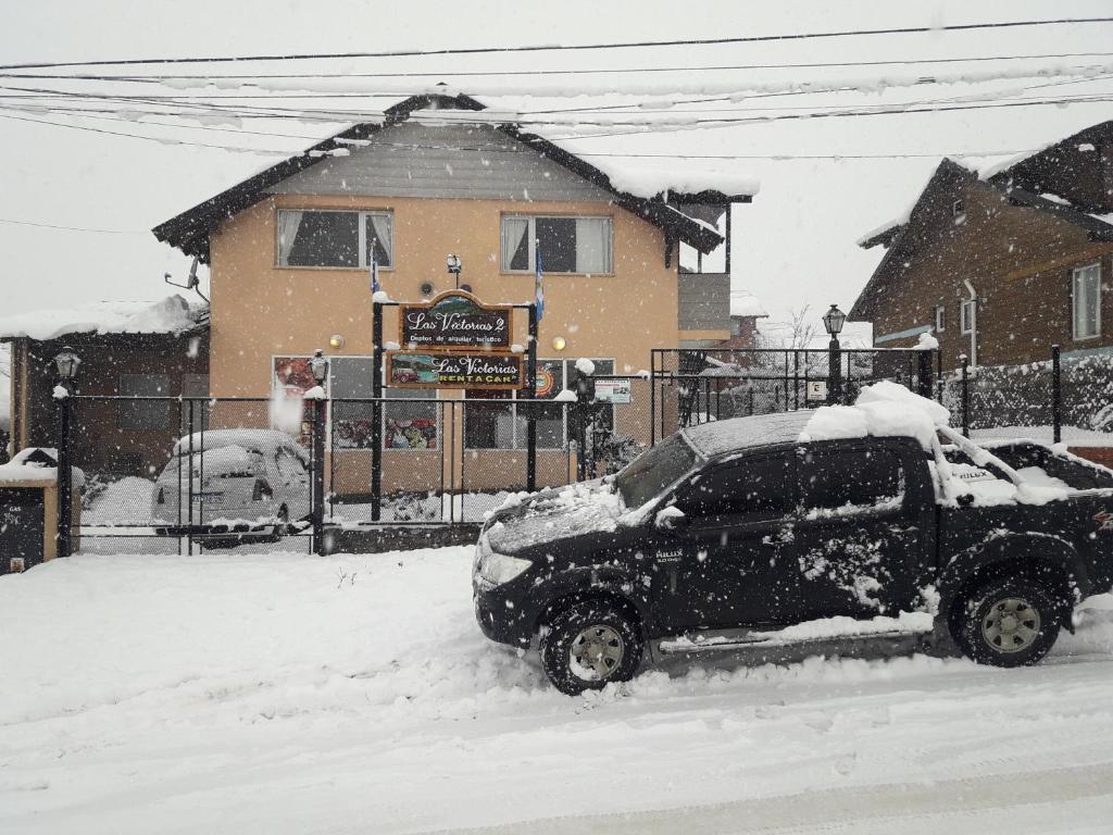 un camión cubierto de nieve delante de una casa en Las Victorias 2 en San Carlos de Bariloche