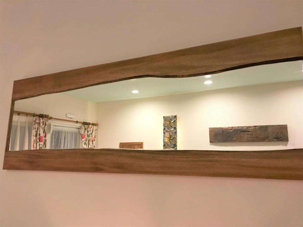 a mirror with a wooden frame on a wall at Kenting COMIC B&amp;B in Hengchun South Gate