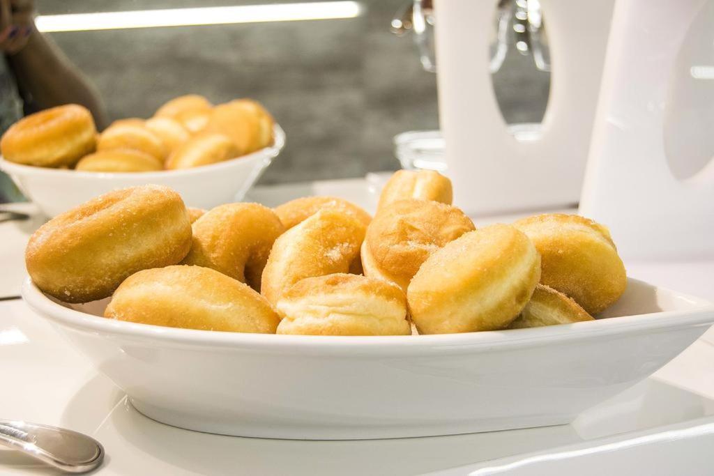 a white bowl of donuts sitting on a table at Pensiunea Junior in Cluj-Napoca