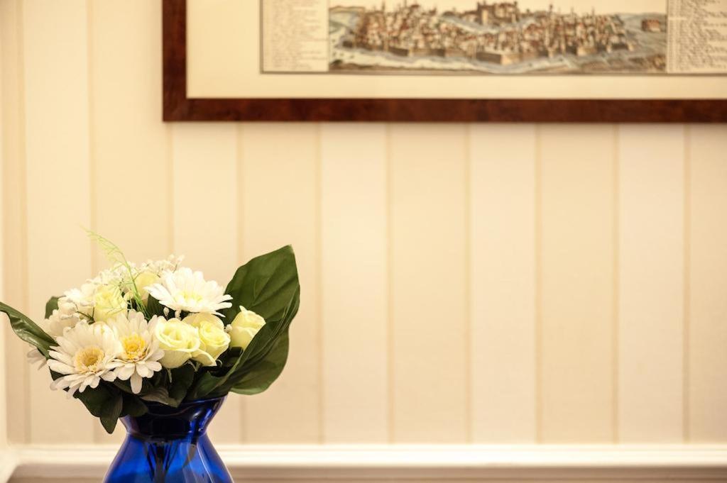 a blue vase filled with white flowers on a table at Pensiunea Junior in Cluj-Napoca