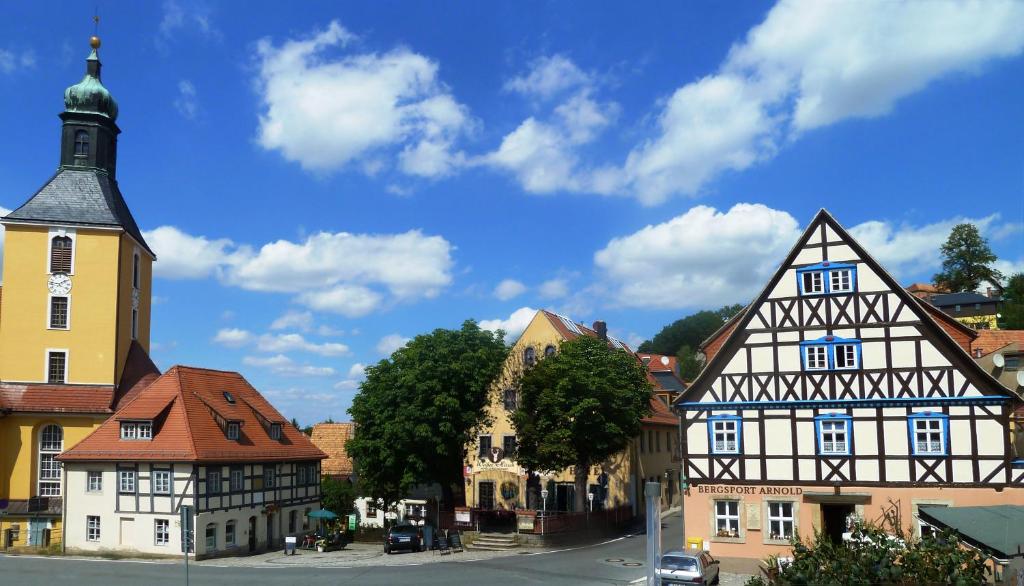 a town with buildings and a church and a street at MB Hotel Weißer Hirsch in Hohnstein