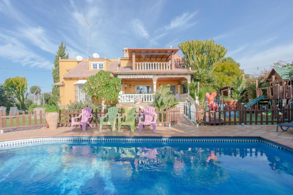 una casa con piscina frente a una casa en Finca Las Velas, en Vélez-Málaga