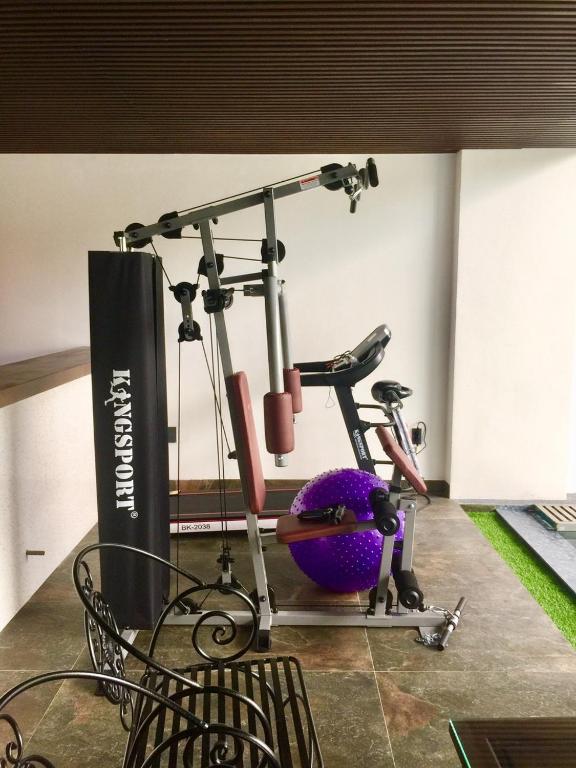 A compact exercise area contains a multi-gym, stationary bike and exercise ball.