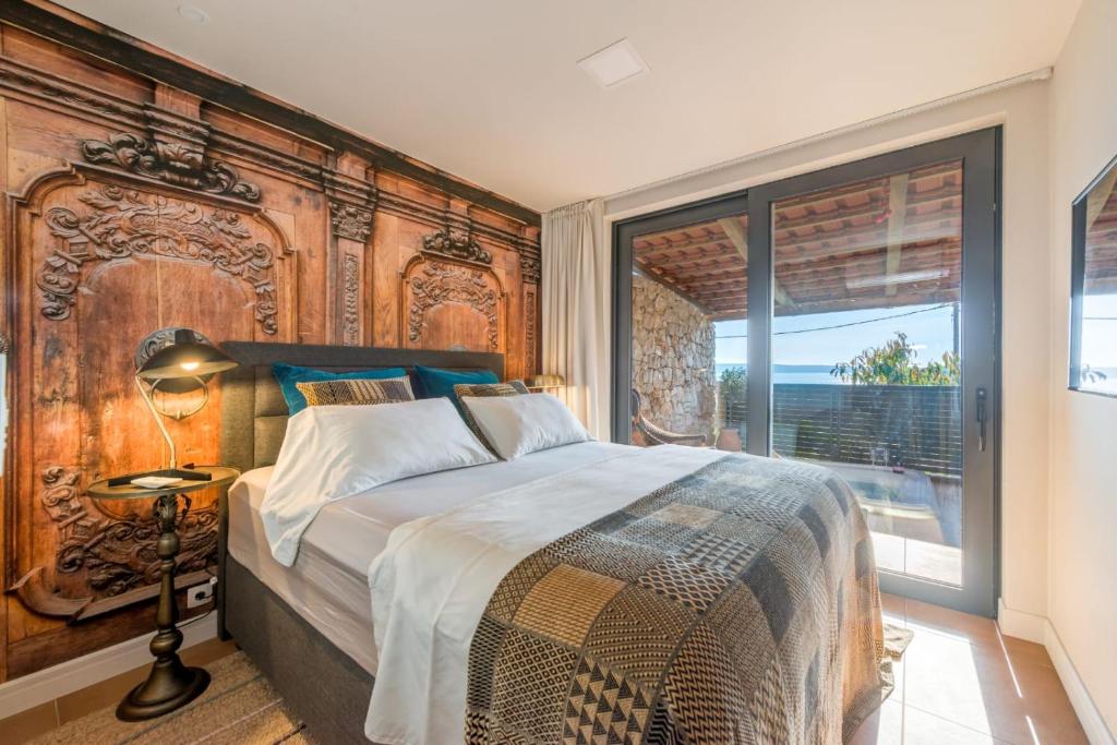 een slaapkamer met een groot bed en een groot raam bij Paradiso Apartment with Private Jacuzzi and Terrace in Trogir