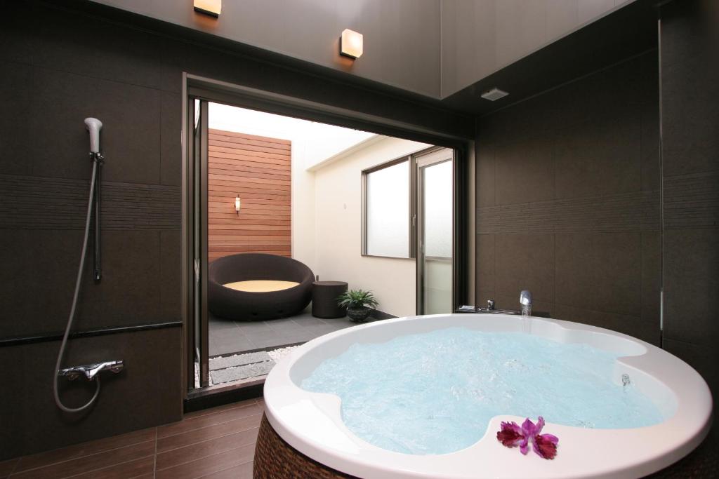 Koshigaya的住宿－HOTEL W-PREMIUM -W GROUP HOTELS and RESORTS-，带浴缸的浴室和大窗户