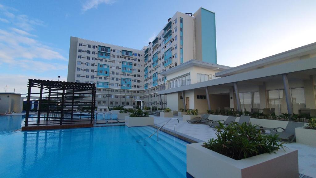 a large hotel with a swimming pool in front of a building at JAS Marina Spatial in Dumaguete