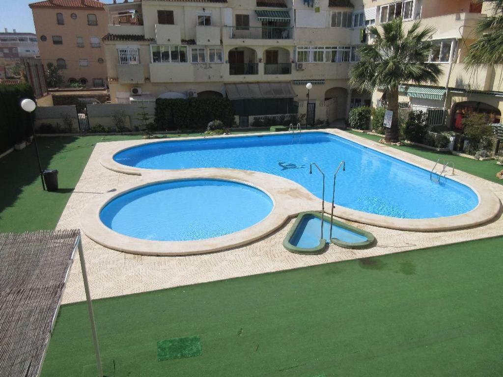 einem großen Pool vor einem Gebäude in der Unterkunft Villa Duplex 8 Persons, Terrace, Swimming Pool And Bbq in Torrevieja
