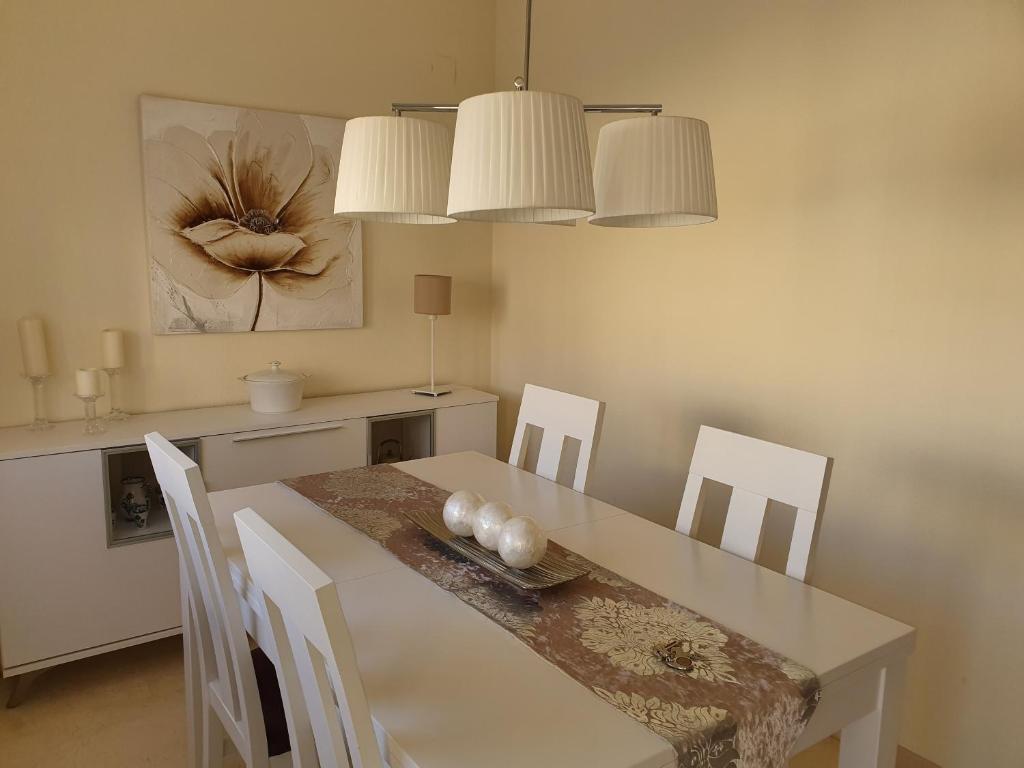 a dining room with a white table and chairs at Jaen Home in Jaén