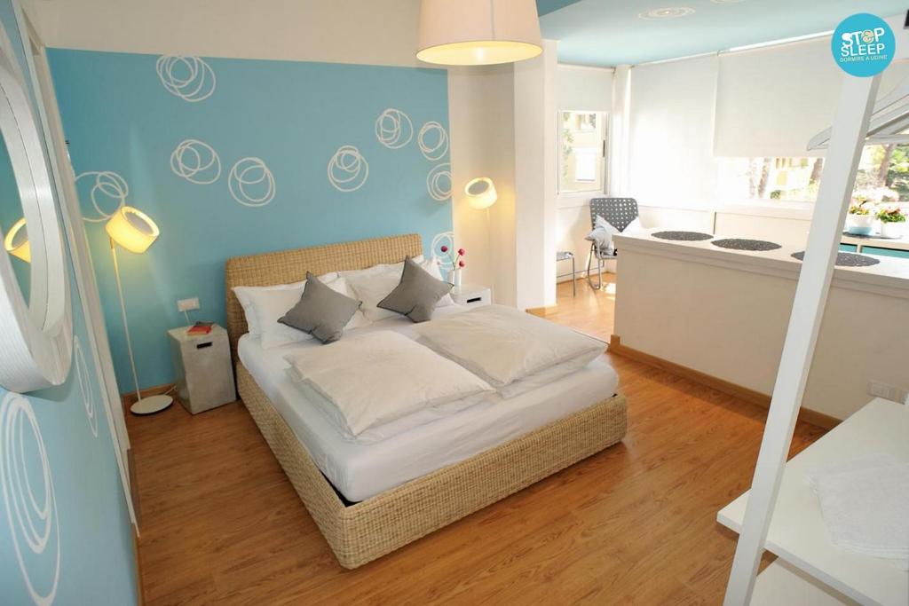 1 dormitorio con 1 cama con pared azul en Stop & Sleep Udine Fronte Ospedale Civile en Udine