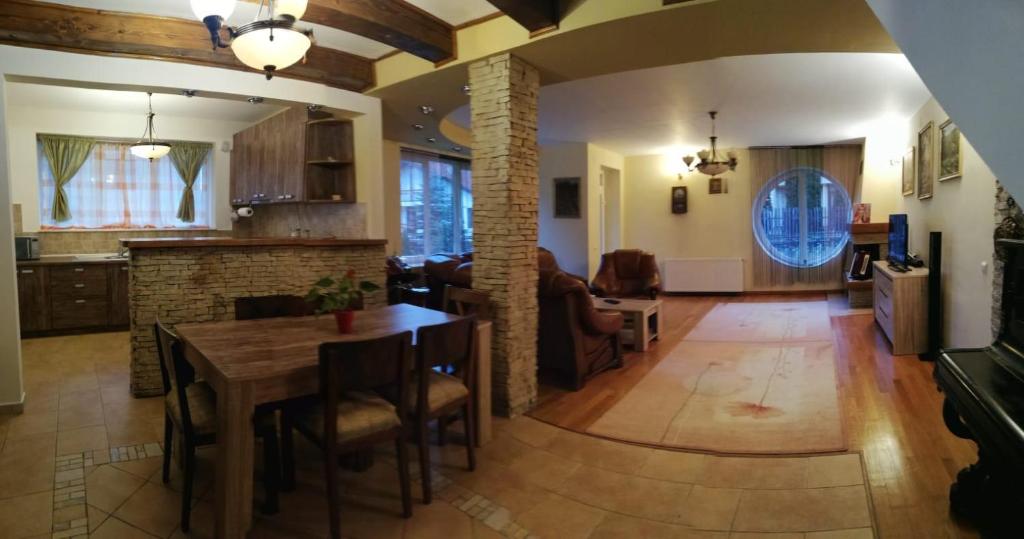 a kitchen and living room with a table and a dining room at Vila Vladimir in Poiana Brasov