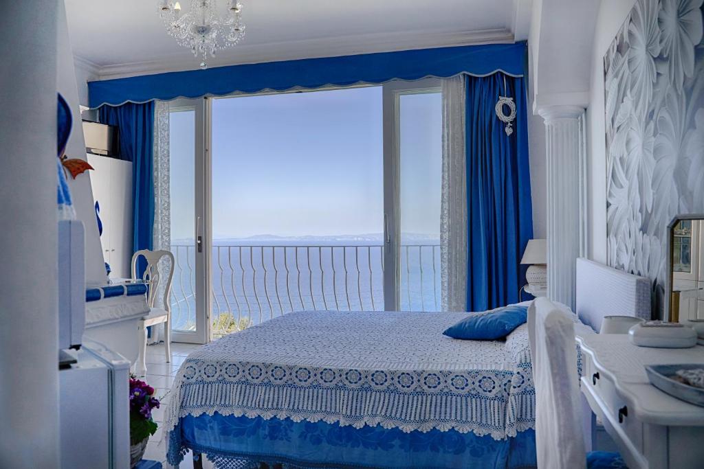 a bedroom with a bed with a view of the ocean at B&B Il Bacio di Capri in Anacapri