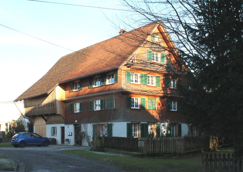 una casa grande con un coche aparcado delante de ella en Ferienwohnung Auszeit, en Dornbirn
