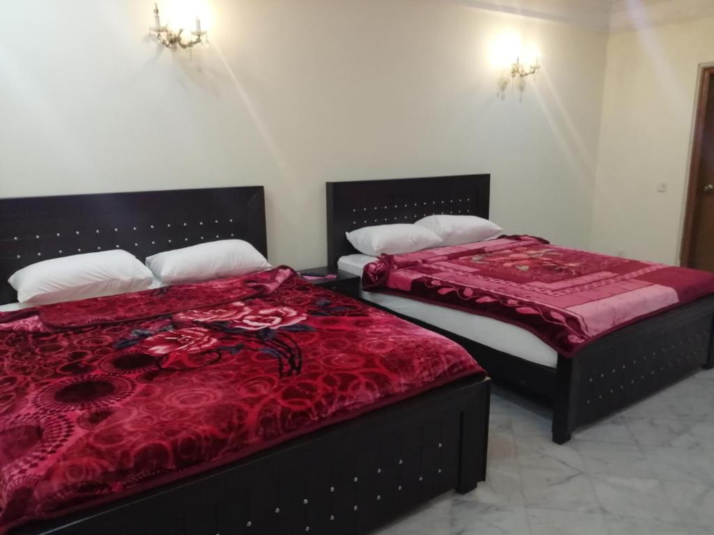拉合爾的住宿－Star Hotel Lahore，两张睡床彼此相邻,位于一个房间里