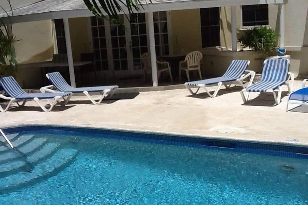 a group of chairs sitting next to a swimming pool at Vida Mejor - East Pool in Saint James